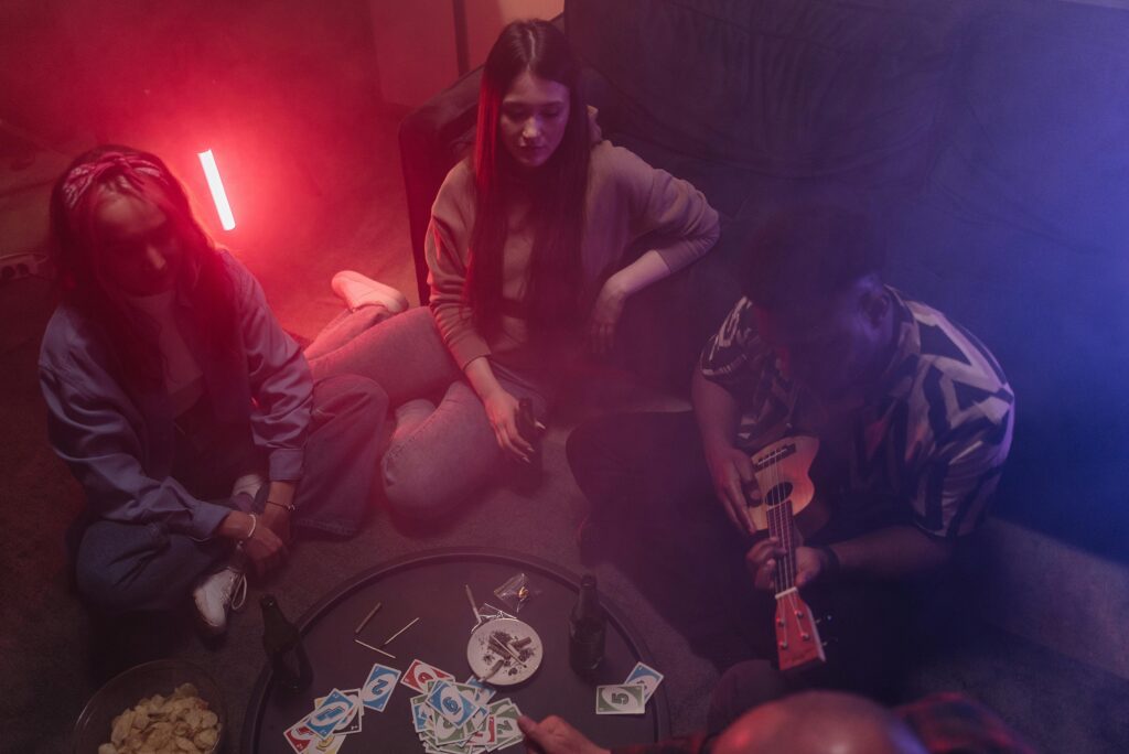 A cozy indoor gathering with friends playing music and games in a relaxed setting.
