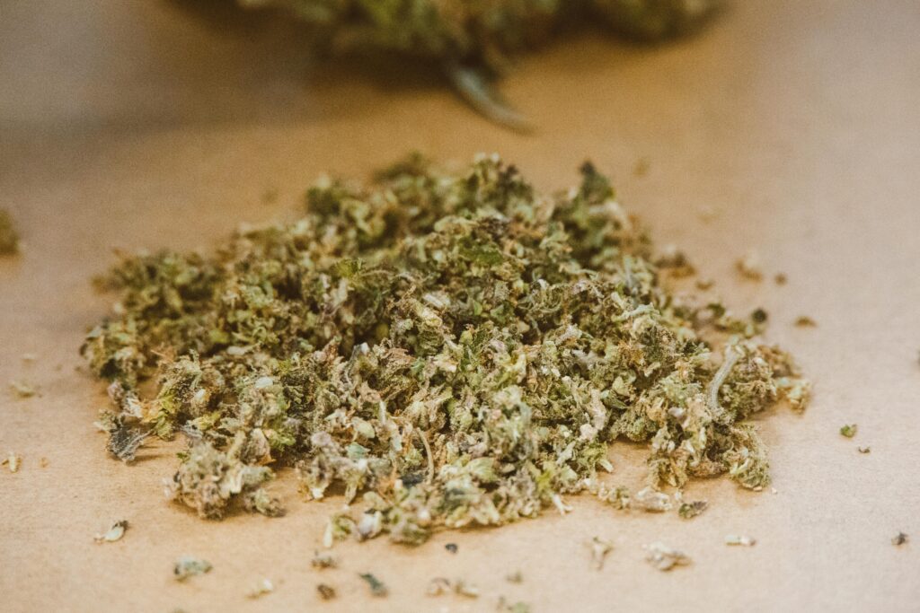 Detailed close-up of dried cannabis buds on a neutral background, highlighting texture and colors.